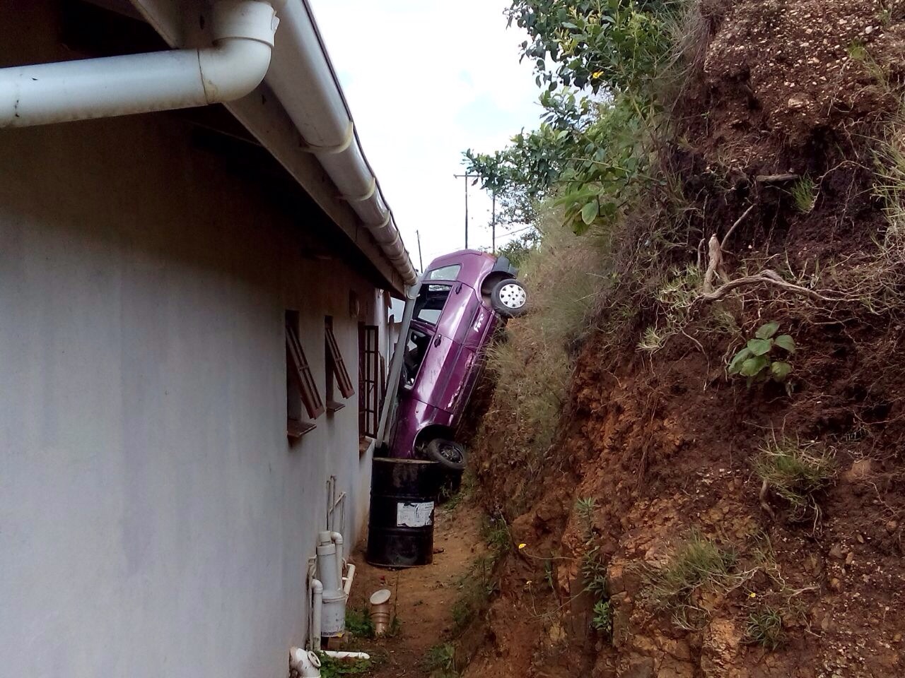 Man injured after vehicle lands between house and embankment