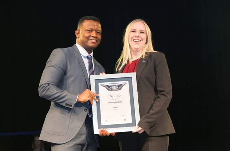 Tracey Delate, General Marketing Manager, Ford Motor Company of Southern Africa receives one of four Ford awards from Nicholas Nkosi, Head of Retail Banking...