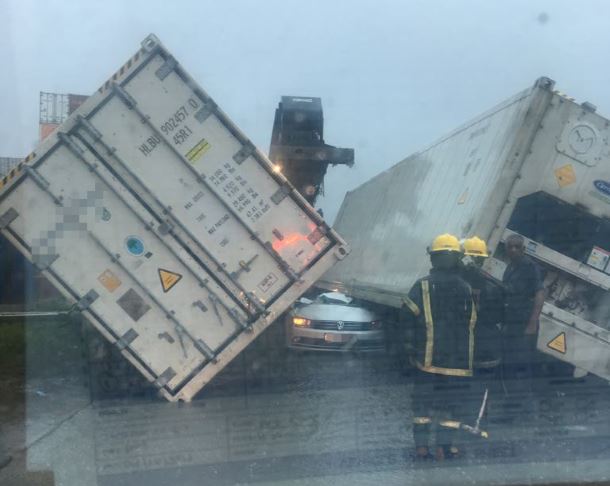 One killed and one injured after shipping containers fell on vehicle