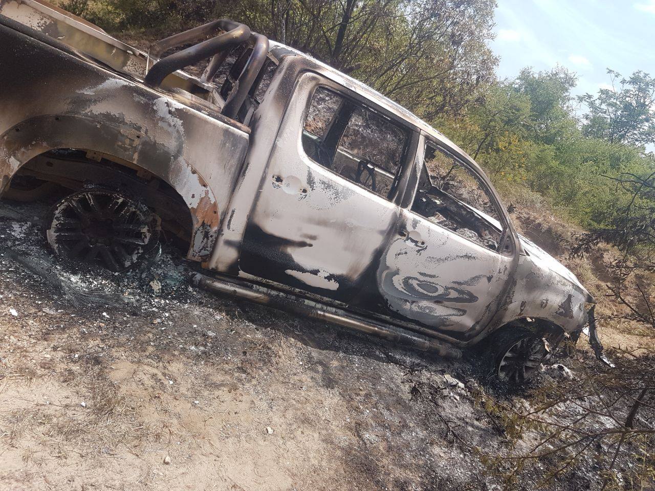Manhunt launched for suspects after reportedly missing person is found in burnt-out vehicle