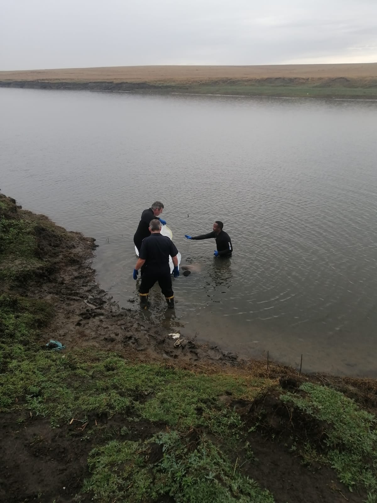 Police divers retrieve a missing man's body from Vaal River