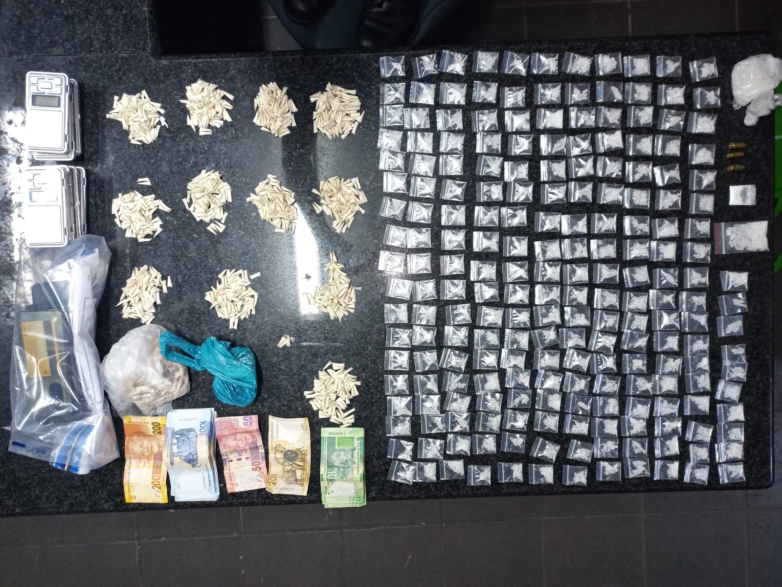 Police members recover a consignment of drugs and cash